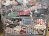 a metal cage filled with lots of clothes in a warehouse