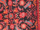 an oriental rug with a red and black design on it