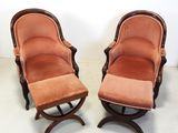 pair of chairs and a ottoman in a room with a white wall
