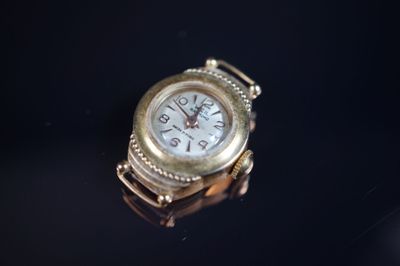 une montre en or posée sur une surface noire