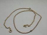 a close up of a gold chain on a white surface