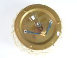 a gold clock with a chain around it on a white surface