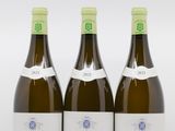 trois bouteilles de vin posées les unes à côté des autres sur une surface blanche