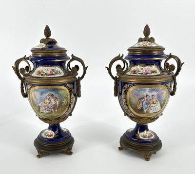 deux vases bleus ornés d'une bordure dorée et d'une peinture