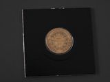 a gold coin on a black surface with a black background