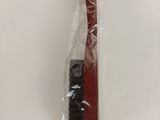 a red toothbrush in a plastic bag on a white table