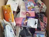 a cardboard box full of children ' s clothing and other items