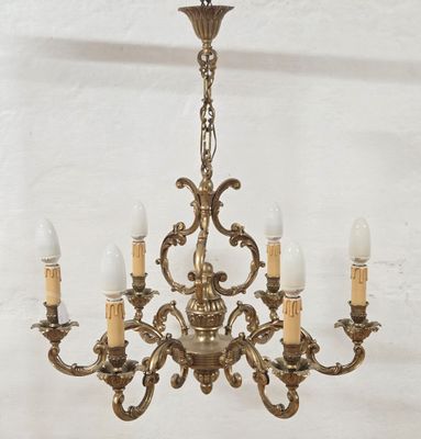 an antique brass chandelier with five lights hanging from the ceiling