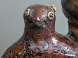a close up of a vase with a bird on it
