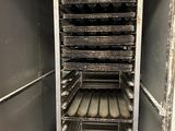 a metal rack with lots of trays of food inside of it