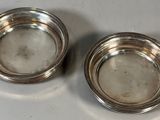 pair of silver plated bowls on a white surface