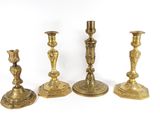 three brass candlesticks are sitting next to each other on a white surface