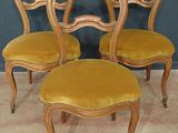 quatre chaises aux assises recouvertes de velours jaune, devant un mur bleu