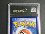 the pokemon card is in a plastic case on a table