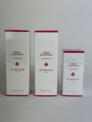 three boxes of perfume sitting next to each other on a white surface