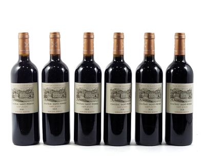 six bottles of wine are lined up on a white surface