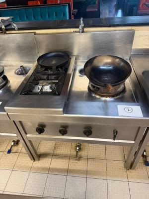 three stoves in the kitchen with a frying pan on top of them