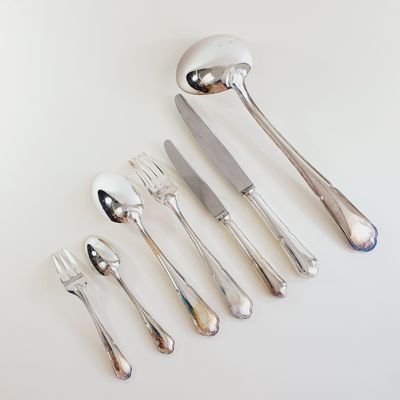 five forks, a spoon, and a knife on the table