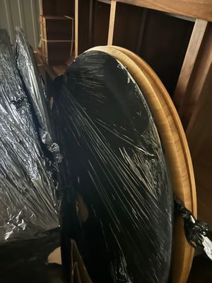 un parapluie noir emballé dans du plastique, posé sur une table en bois