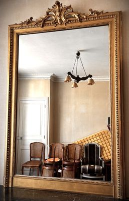 a large mirror in the middle of a room with chairs