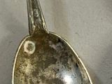 a silver spoon with a spoon handle on a table