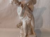 une statue représentant une femme tenant un panier de fleurs