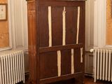 a wooden cabinet in the corner of a room next to a radiator