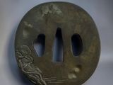 a picture of a bronze tsubai with a design of a man and a woman