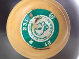 a close up of a yellow frisbee with a green label on it