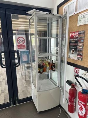 une vitrine située dans un coin d'un magasin, avec un extincteur