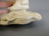 une main tenant une petite statuette représentant un homme