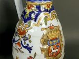a white and blue vase with a coat of arms on it