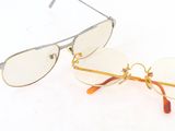 une paire de lunettes à monture dorée et à verres transparents posée sur une surface blanche