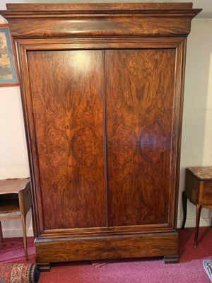 une armoire en bois dans une pièce où il y a un tapis au sol