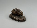 une photo d'une statue en bronze représentant une souris posée sur un socle