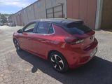 the rear end of a red car parked in front of a building