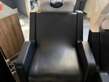 une chaise noire dans un coin d'un salon de coiffure