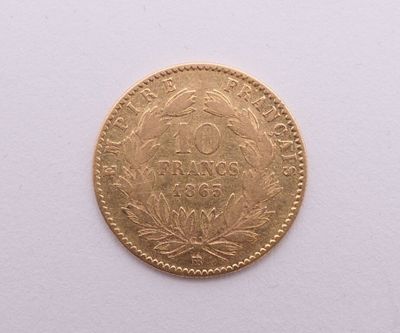 gros plan d'une pièce d'or sur une surface blanche