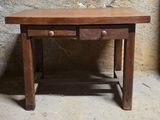 une petite table en bois surmontée de deux tiroirs