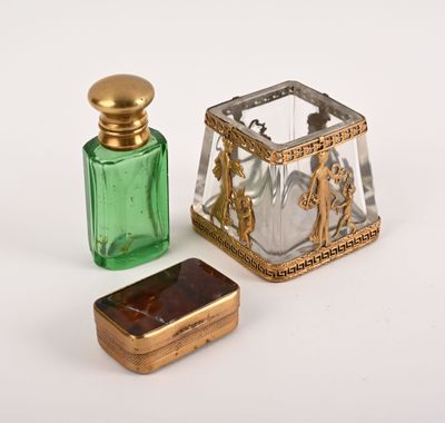 une petite bouteille en verre avec un bouchon doré, à côté d'une petite bouteille en verre verte avec un bouchon doré