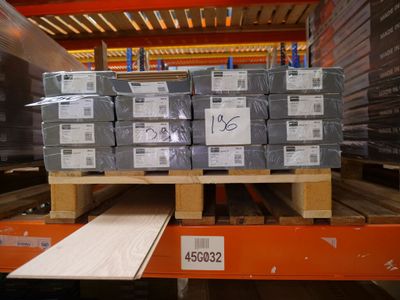 une palette remplie de cartons, placée sur une autre palette dans un entrepôt