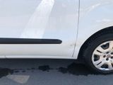 a small white car parked on the side of the road