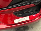 a close up of a red car with a sticker on it