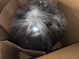 une boîte contenant une balle emballée dans du plastique