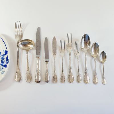 a lot of silverware on the table and a plate