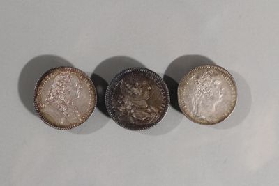 trois types de pièces différents posés sur une surface blanche