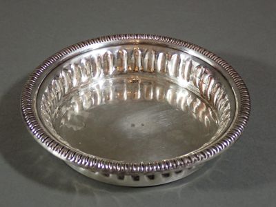 Dessous de bouteille en métal argenté à décor godronné.
