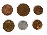 six different types of coins sitting on top of a white surface