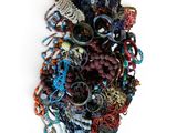 une pile de bijoux assortis sur une surface blanche