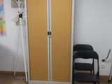 a black chair in a room with a yellow door